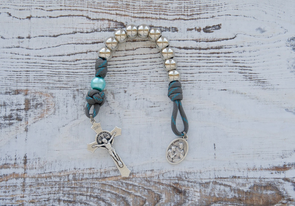 St. Anne's Intercession - 1 Decade Paracord Rosary in gray and blue, featuring durable paracord rope, silver Hail Mary beads, sky blue Our Father beads, and a devotional St. Anne medal for spiritual warfare and prayer.
