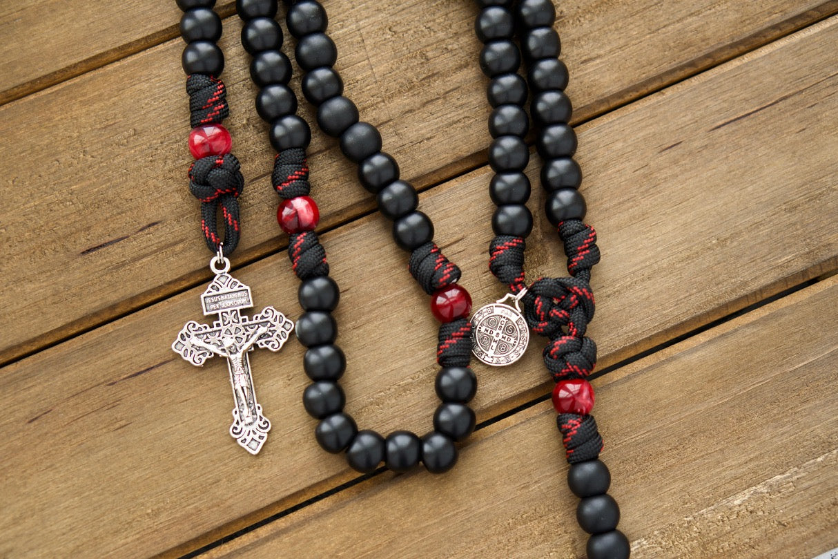 The Blood of Christ - 5 Decade Paracord Rosary, a premium unbreakable paracord rosary with a silver pardon crucifix and St. Benedict medal, featuring black and red rope with black and maroon/red beads for a powerful symbol of faith and devotion in your daily Catholic prayers.