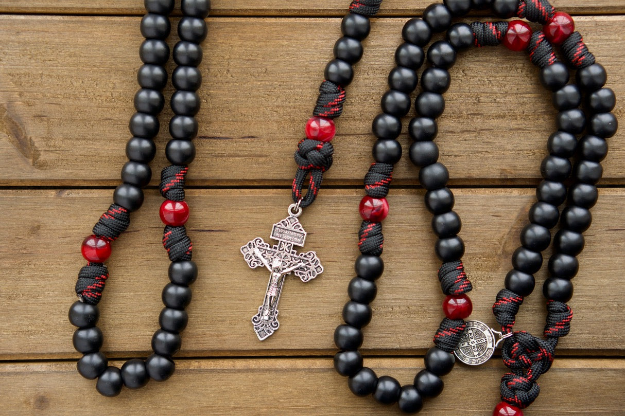 Embrace the power of The Blood of Christ - 5 Decade Paracord Rosary with its premium, unbreakable construction and stunning design featuring a silver pardon crucifix, a St. Benedict medal, and vibrant black and maroon/red beads, perfect for daily prayer and special occasions.