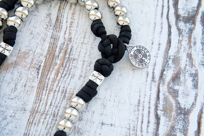 The Iron Will - Black and Silver - 5 Decade Paracord Rosary: A durable, premium, and unbreakable Catholic gift for spiritual warriors featuring silver Hail Mary beads, unique Crusader cross Our Father beads, St. Benedict medal centerpiece, and a full-size 19" Holy Trinity Crucifix.