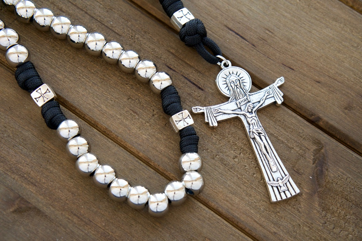 The Iron Will - Black and Silver - 5 Decade Paracord Rosary: Durable paracord rosary featuring silver beads, unique Crusader cross Our Father beads, St. Benedict medal centerpiece, and a full-size 19 inch length with a robust 2.75" Holy Trinity Crucifix for unbreakable spiritual strength.