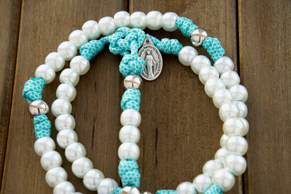 Sanctus Servo's Peaceful Waters - White, Silver, and Teal Blue - 5 Decade Rosary: A durable and elegant 19-inch paracord rosary with pearl Hail Mary beads, silver Our Father beads, St. Benedict Crucifix, and Miraculous Medal for modern women to elevate their prayer life and conquer spiritual battles.