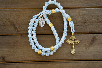 Unleash the power of unshakable faith with Sanctus Servo's premium white, blue, and gold rope rosary - an unbreakable Catholic gift perfect for everyday spiritual battles. Featuring durable paracord 550 rope, gold Our Father beads, a standard size 2" Gold Pardon Crucifix, and a devotional Miraculous Medal, this full-size (19 inches) rosary is designed to last and accompany you on your faith journey.
