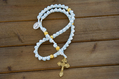 Unleash the power of your unshakable faith with Sanctus Servo's White, Blue and Gold Rope Rosary, a premium, durable paracord rosary designed to stand strong in your spiritual battles. This stunning 19-inch rosary features gold Our Father beads, a standard size 2" Gold Pardon Crucifix, and a devotional Miraculous Medal, all crafted with top-quality materials for unwavering strength and endurance.